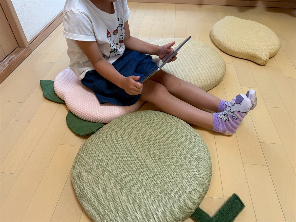 たたみだもんのももに座る子ども